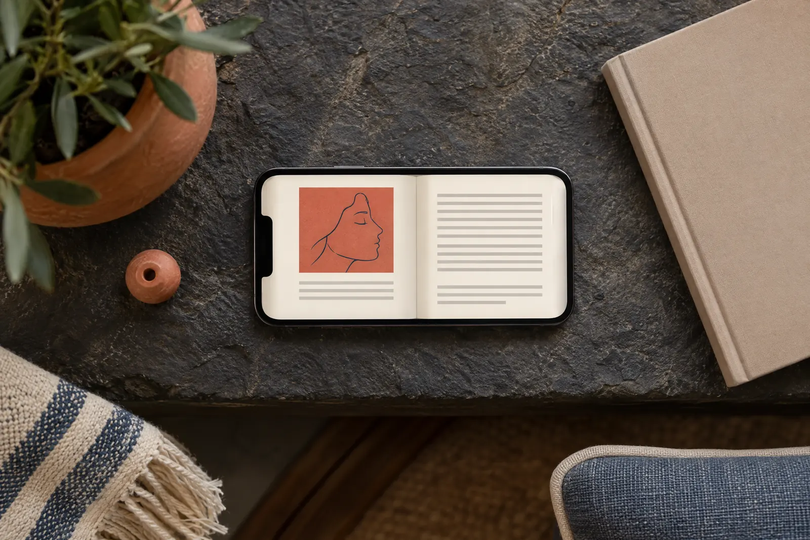 A covered porch still life of a book product arranged with a clay bead, in coral, sand, slate, and cream.