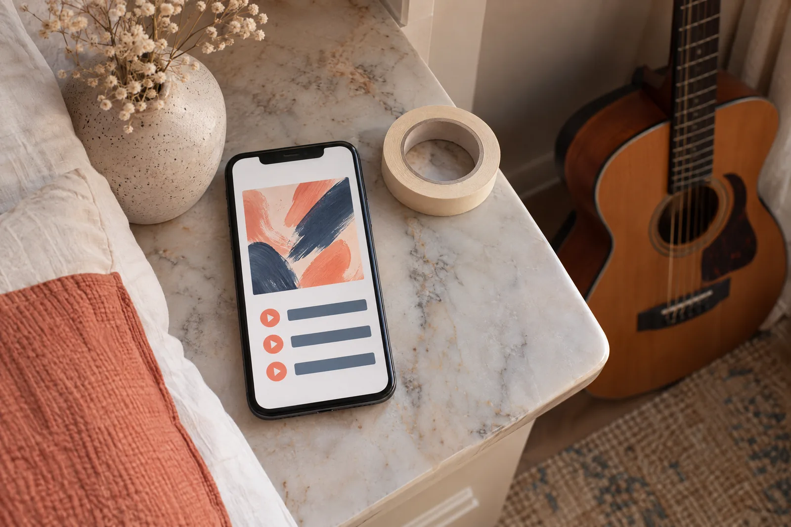 A bedroom alcove still life of a music product arranged with a roll of masking tape, in coral, sand, slate, and cream.